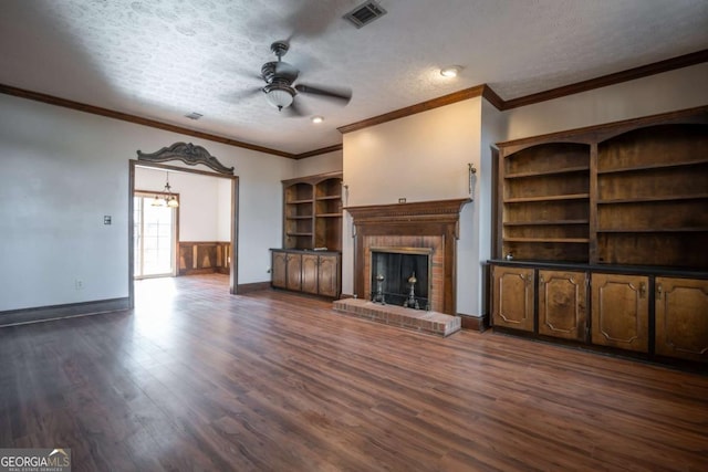 unfurnished living room with dark wood-type flooring, ceiling fan, a brick fireplace, and a textured ceiling