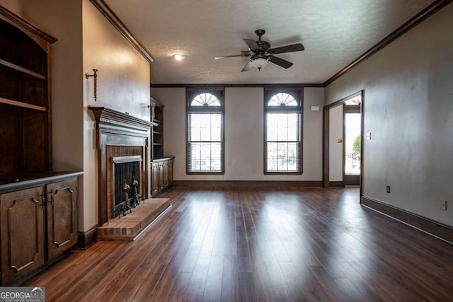 unfurnished living room with a brick fireplace, dark wood-type flooring, ornamental molding, and a textured ceiling