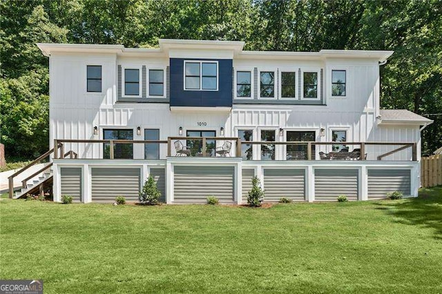 back of property featuring a lawn and a deck