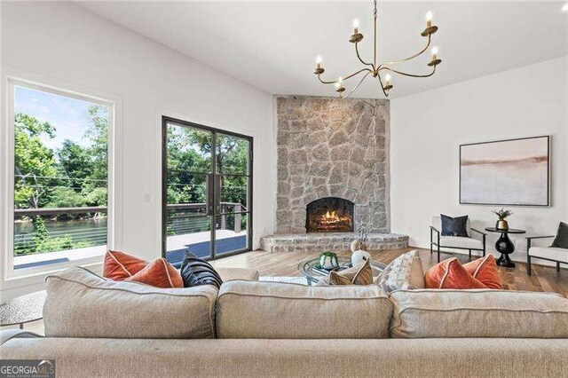 living room featuring a healthy amount of sunlight, a fireplace, and a notable chandelier