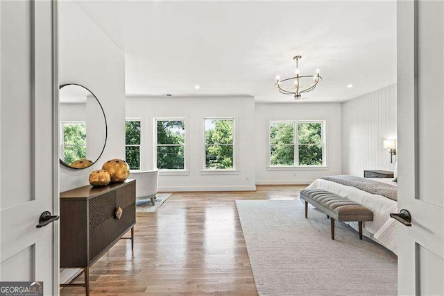 bedroom with light hardwood / wood-style floors and a notable chandelier