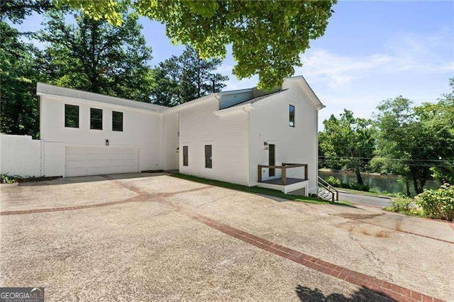 view of home's exterior with a garage and a water view