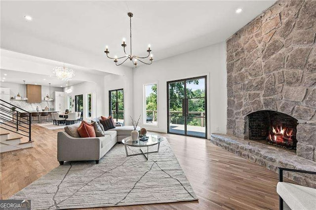 living room with a fireplace, a chandelier, and light hardwood / wood-style floors