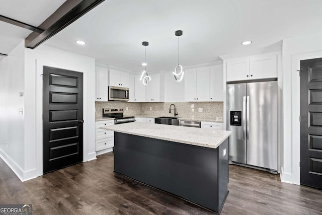 kitchen with white cabinetry, decorative light fixtures, a center island, and appliances with stainless steel finishes