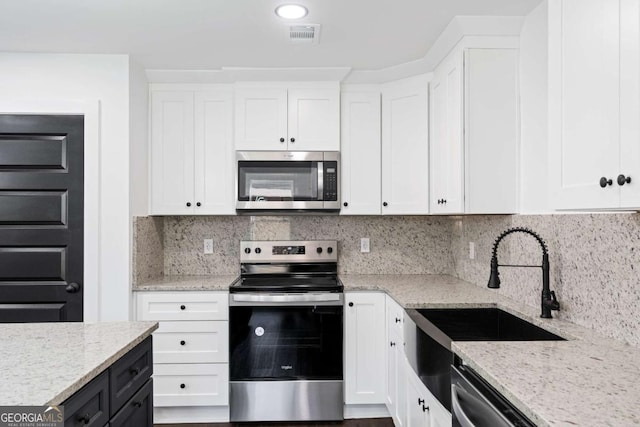 kitchen featuring stainless steel appliances and white cabinetry