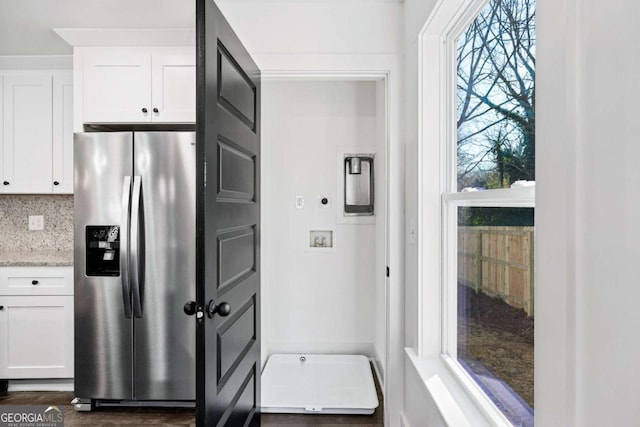 kitchen with dark wood-type flooring, white cabinetry, light stone counters, stainless steel fridge with ice dispenser, and decorative backsplash