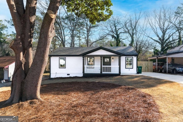 ranch-style house featuring a porch, a carport, and a front yard