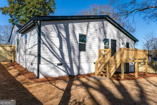 rear view of property featuring a wooden deck