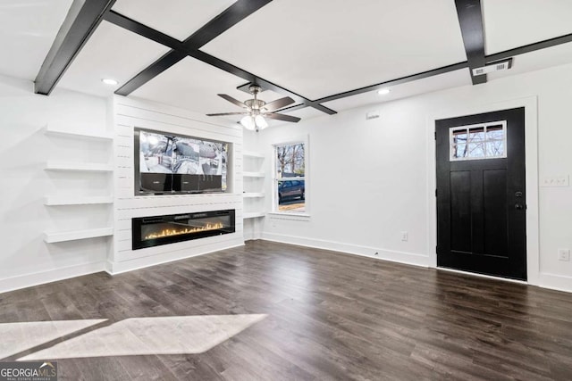 unfurnished living room featuring beam ceiling, dark wood-type flooring, a wealth of natural light, and a fireplace