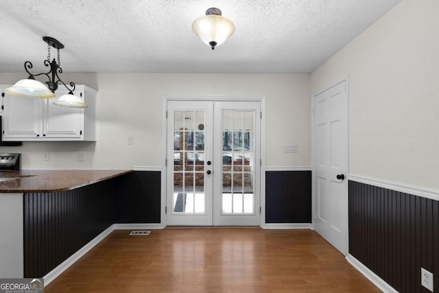 doorway to outside with hardwood / wood-style floors, a textured ceiling, and french doors