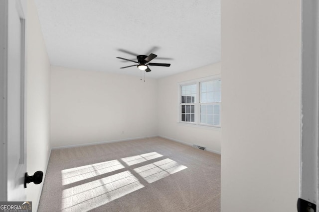 carpeted empty room featuring ceiling fan