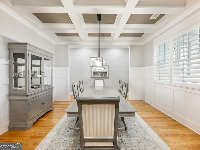 dining space with beamed ceiling, coffered ceiling, and light hardwood / wood-style flooring