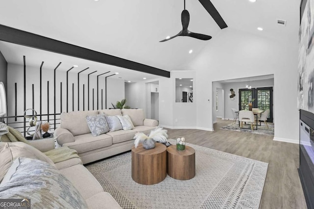 living room with light hardwood / wood-style flooring, high vaulted ceiling, and ceiling fan