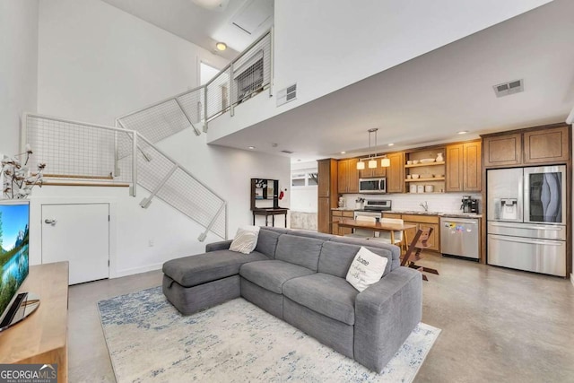 living room featuring a towering ceiling and sink