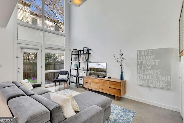 living room with concrete flooring and a high ceiling