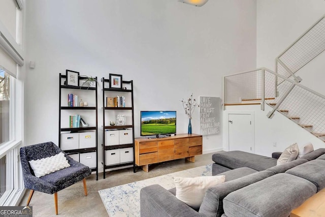 living room with concrete flooring and a towering ceiling