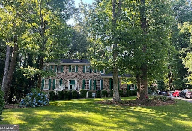 colonial house featuring a front lawn