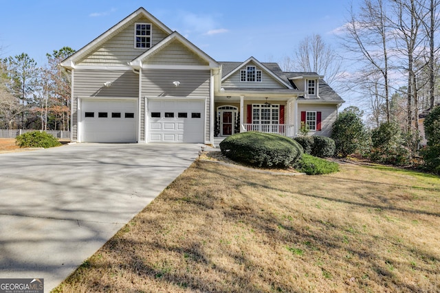 front of property featuring a porch, a garage, and a front lawn