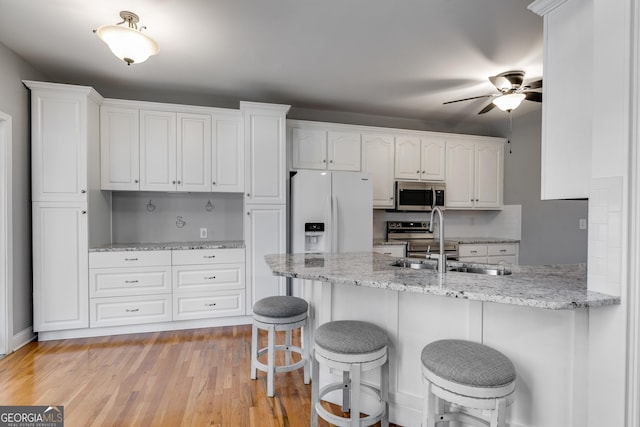 kitchen featuring white cabinetry, appliances with stainless steel finishes, kitchen peninsula, and sink