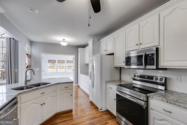 kitchen featuring stainless steel appliances, white cabinetry, sink, and a healthy amount of sunlight