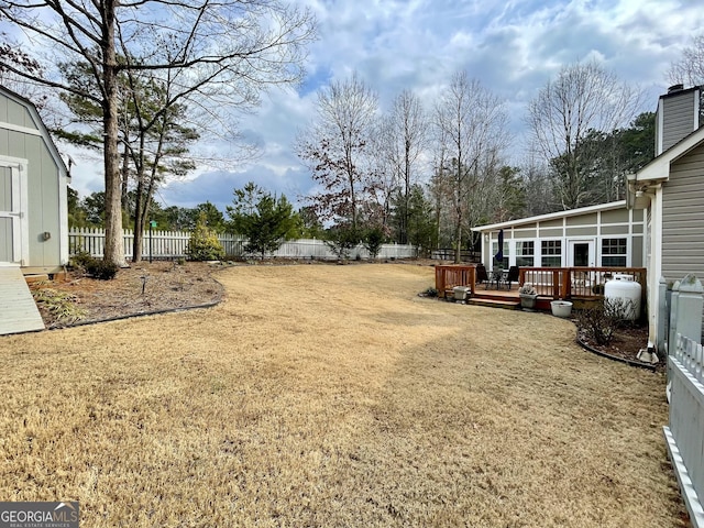 view of yard with a deck and a storage shed