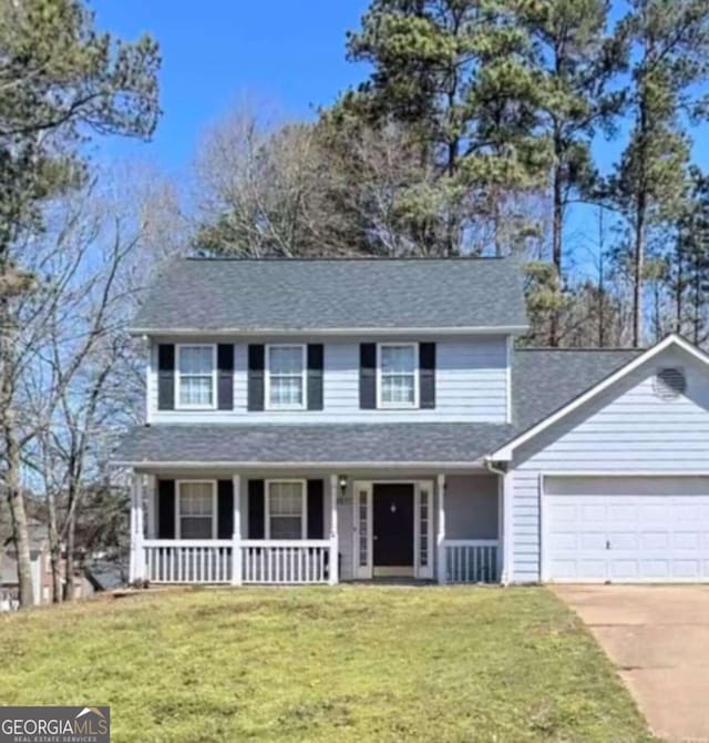 traditional home with driveway, a front lawn, a porch, and an attached garage