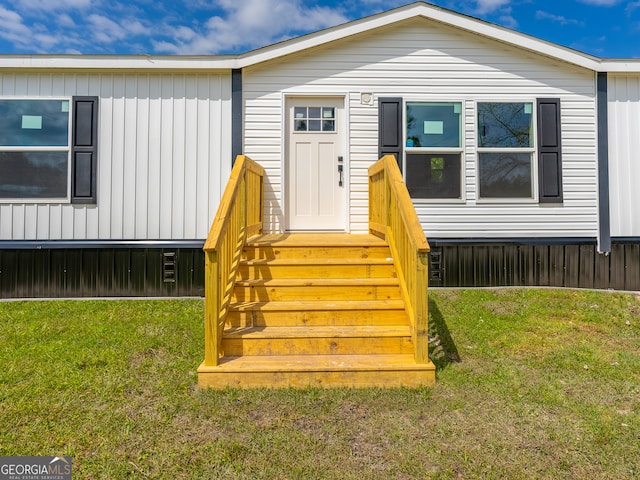 view of exterior entry with a lawn