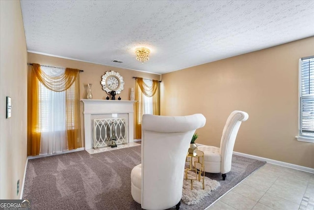 sitting room with a healthy amount of sunlight, light tile patterned floors, and a textured ceiling