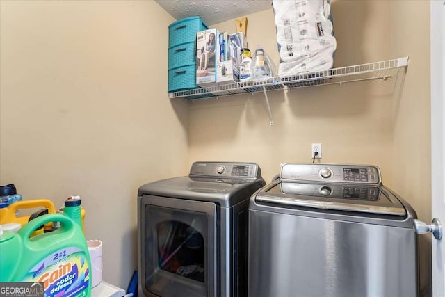 laundry area featuring a textured ceiling and washing machine and clothes dryer