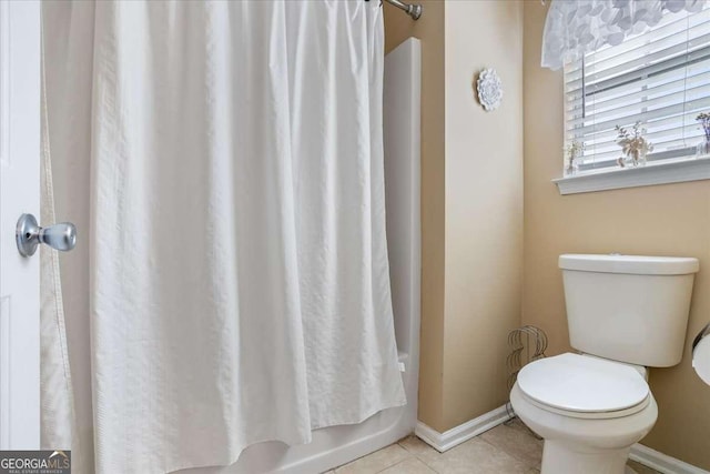 bathroom featuring tile patterned flooring, toilet, and shower / bathtub combination with curtain