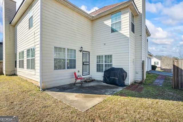 rear view of property with a lawn and a patio area