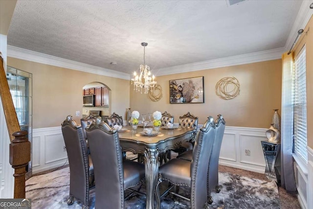 dining area featuring a notable chandelier, crown molding, and a textured ceiling