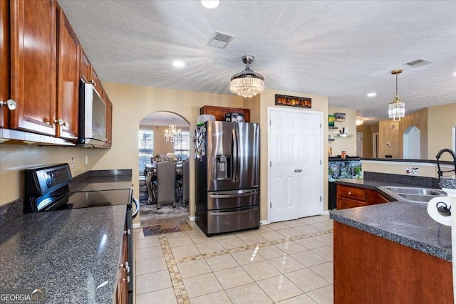 kitchen with black electric range oven, sink, light tile patterned floors, stainless steel fridge, and pendant lighting