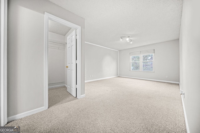 23 Chelsea Ct, Avondale Estates, GA 30002 - unfurnished bedroom with a spacious closet, a textured ceiling, carpet flooring, and baseboards