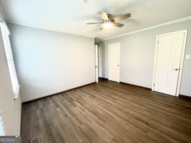 unfurnished bedroom featuring crown molding, dark hardwood / wood-style floors, ceiling fan, and a textured ceiling