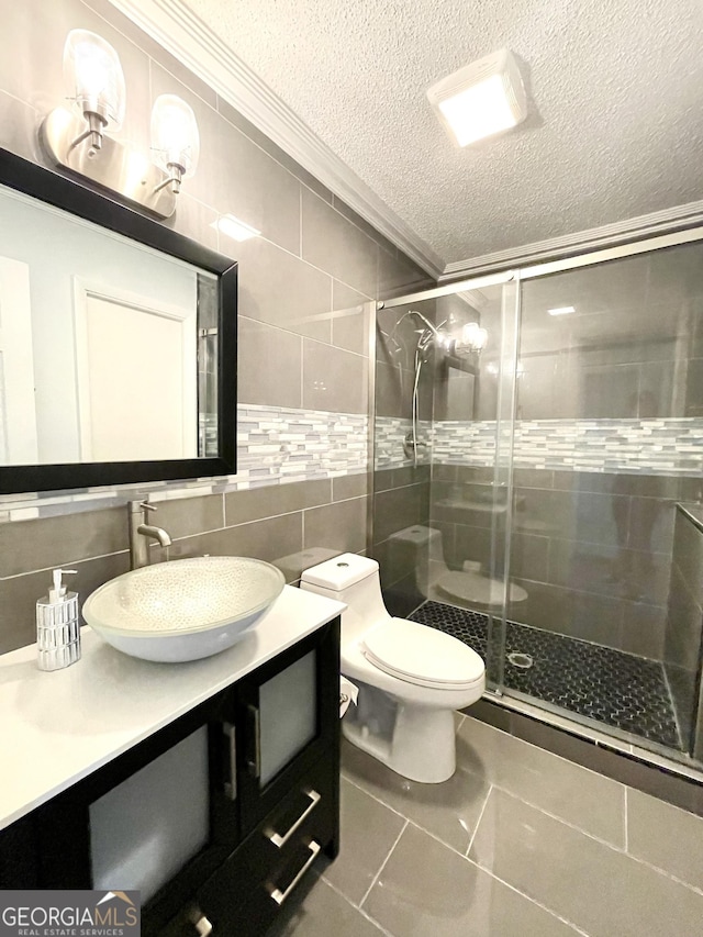 bathroom featuring a shower with door, ornamental molding, tile walls, and a textured ceiling