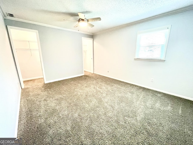 carpeted empty room with crown molding, ceiling fan, and a textured ceiling