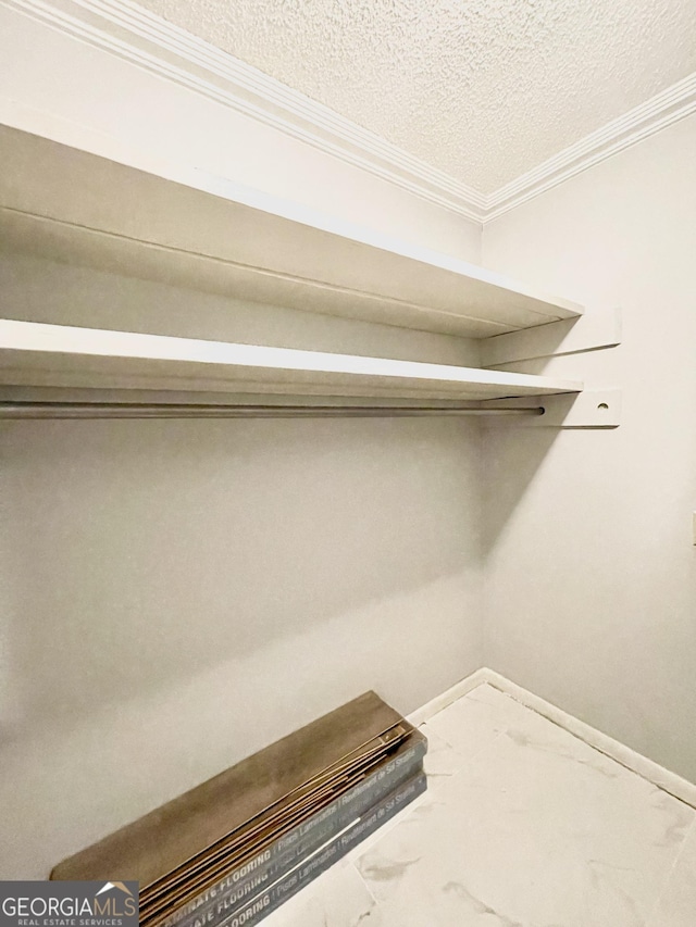 laundry area with crown molding and a textured ceiling