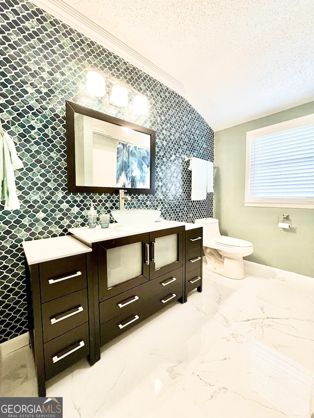 bathroom with ornamental molding, vanity, a textured ceiling, and toilet