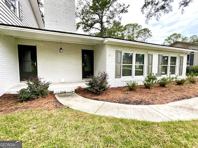 view of exterior entry featuring a yard