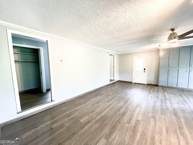 interior space featuring ceiling fan, ornamental molding, light hardwood / wood-style flooring, and a textured ceiling