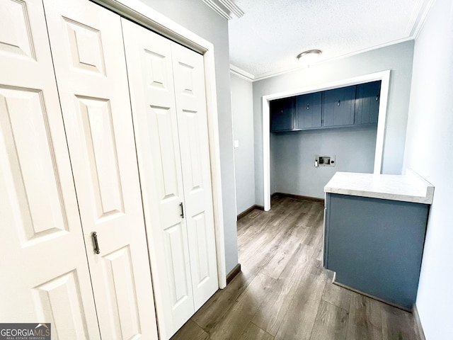 laundry room featuring crown molding, cabinets, a textured ceiling, dark hardwood / wood-style flooring, and hookup for a washing machine