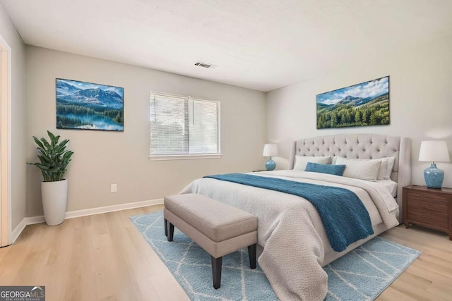 bedroom featuring light wood-type flooring, visible vents, and baseboards
