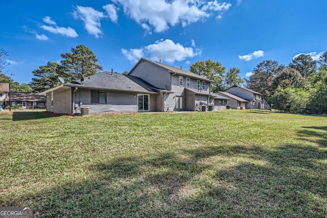 rear view of property with a yard and central air condition unit