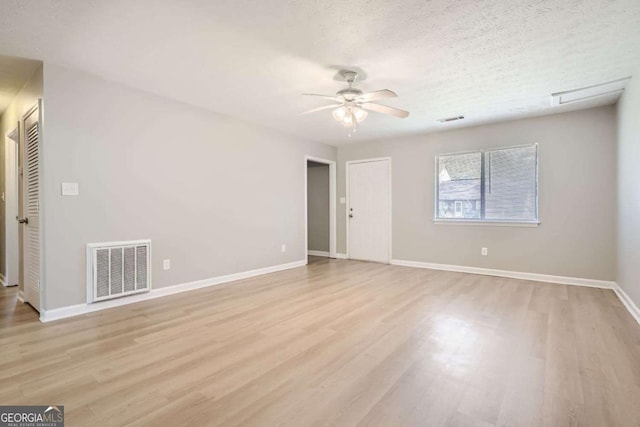 spare room with visible vents, light wood finished floors, baseboards, and ceiling fan