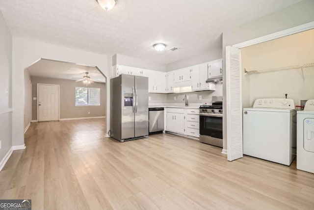 kitchen with white cabinetry, appliances with stainless steel finishes, washer and clothes dryer, and light hardwood / wood-style flooring