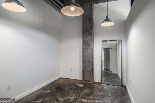 unfurnished room featuring concrete flooring and a high ceiling