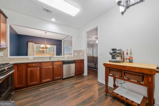 kitchen with sink, stainless steel appliances, decorative backsplash, dark hardwood / wood-style flooring, and decorative light fixtures