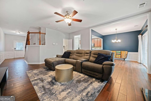 living room featuring wood-type flooring and ceiling fan with notable chandelier