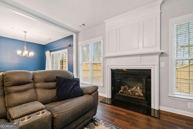 living room featuring a notable chandelier and dark wood-type flooring